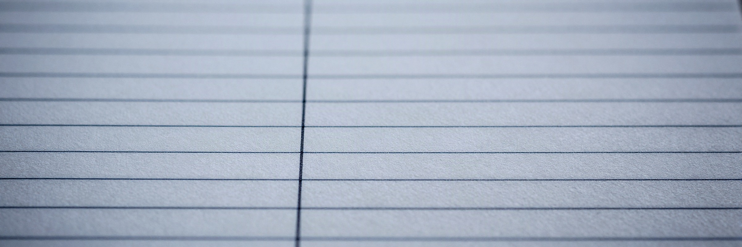 A close crop of ruled ledger paper, aligned printed rules running across the frame.