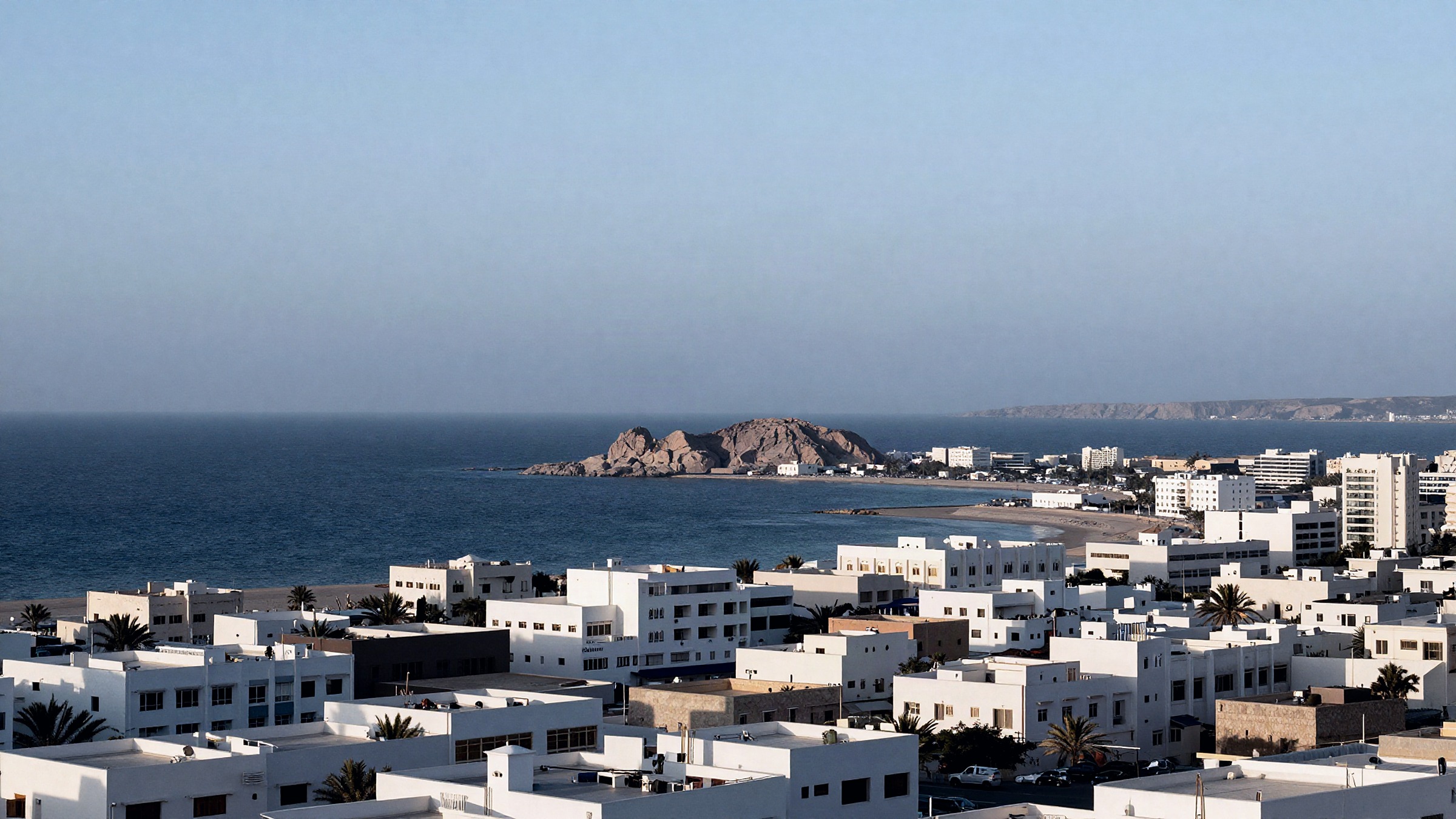 An elevated view over Muscat toward the coast in flat morning light.